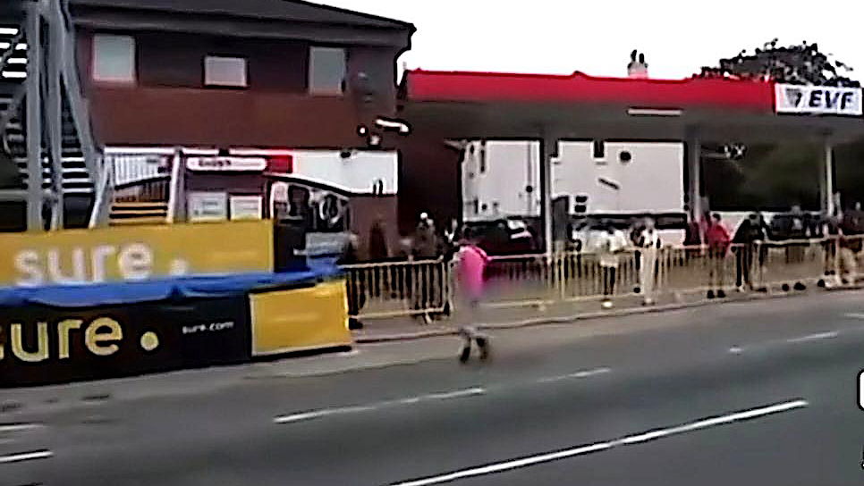 A man crosses the lice TT course during a race